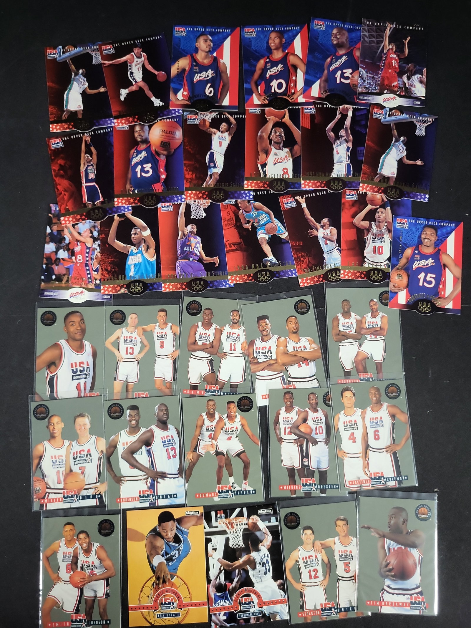 I03818 | A Collection of USA Basketball Trading Cards Featuring Upper Deck and SkyBox Series: BID PER WHAT YOU SEE IN THE PHOTO, NOT THE AI GENERATED TITLES AND DESCRIPTIONS! This collection of basketball trading cards from the mid-1990s predominantly features members of the USA Basketball men