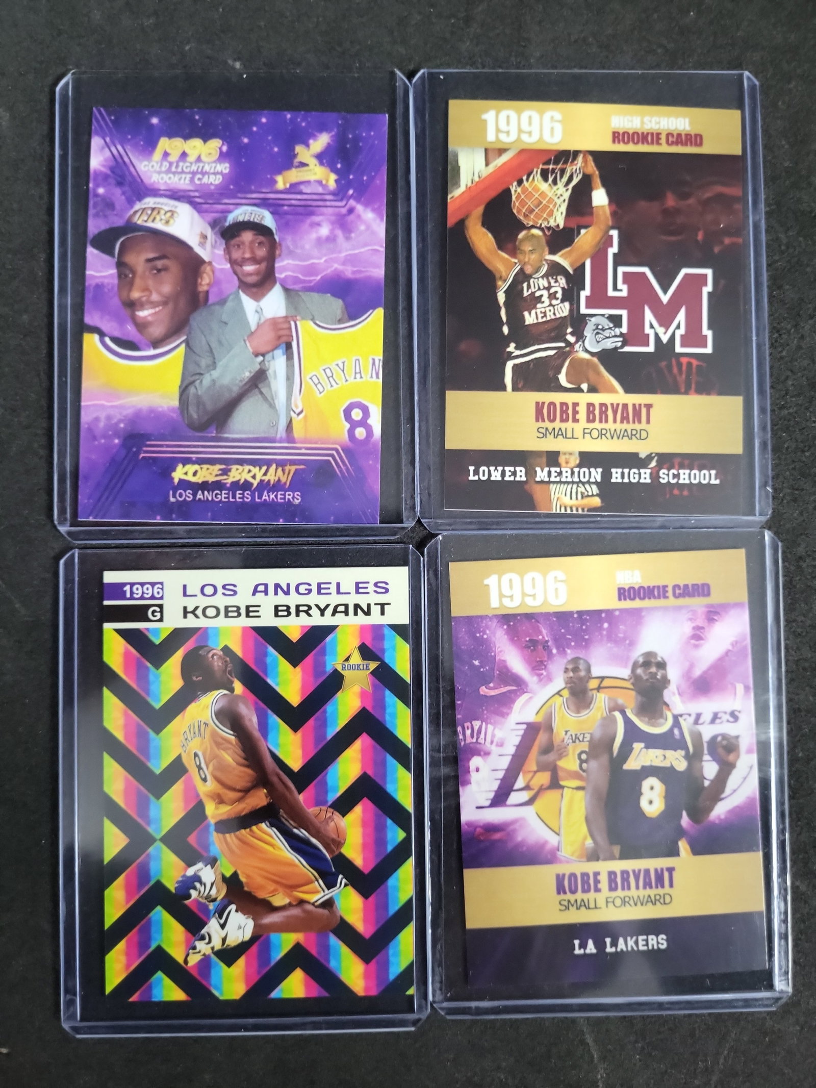 I03281 | A Lot of Four 1996 Kobe Bryant Unlicensed Novelty Rookie Trading Cards: BID PER WHAT YOU SEE IN THE PHOTO, NOT THE AI GENERATED TITLES AND DESCRIPTIONS! This lot comprises four independent and unlicensed trading cards featuring Kobe Bryant from the 1996 rookie period. Inc