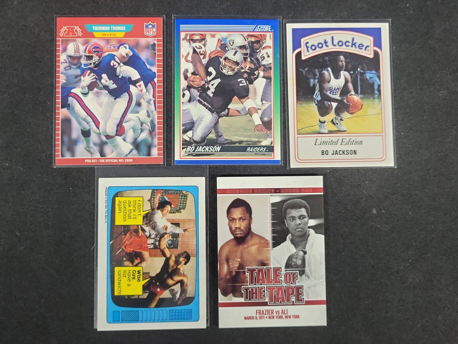 I03167 | Five Assorted Sports and Entertainment Trading Cards Including Bo Jackson and Thurman: BID PER WHAT YOU SEE IN THE PHOTO, NOT THE AI GENERATED TITLES AND DESCRIPTIONS! Five Assorted Sports and Entertainment Trading Cards Including Bo Jackson and Thurman Thomas This collection consists o