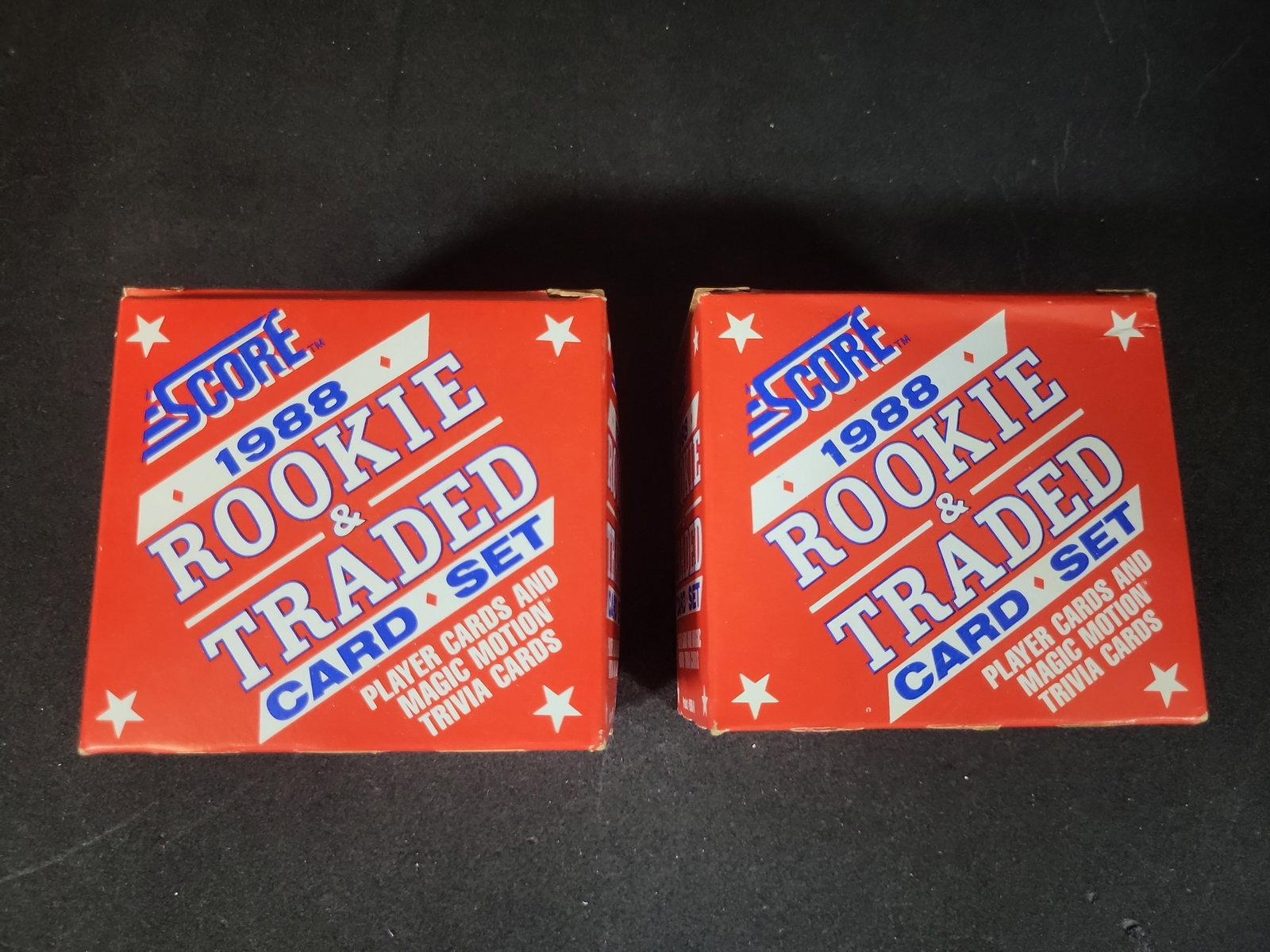 I03250 | A Pair of 1988 Score Rookie and Traded Baseball Card Boxed Sets: BID PER WHAT YOU SEE IN THE PHOTO, NOT THE AI GENERATED TITLES AND DESCRIPTIONS! This lot features a pair of original 1988 Score Rookie & Traded baseball card complete boxed sets. Each box contains a 