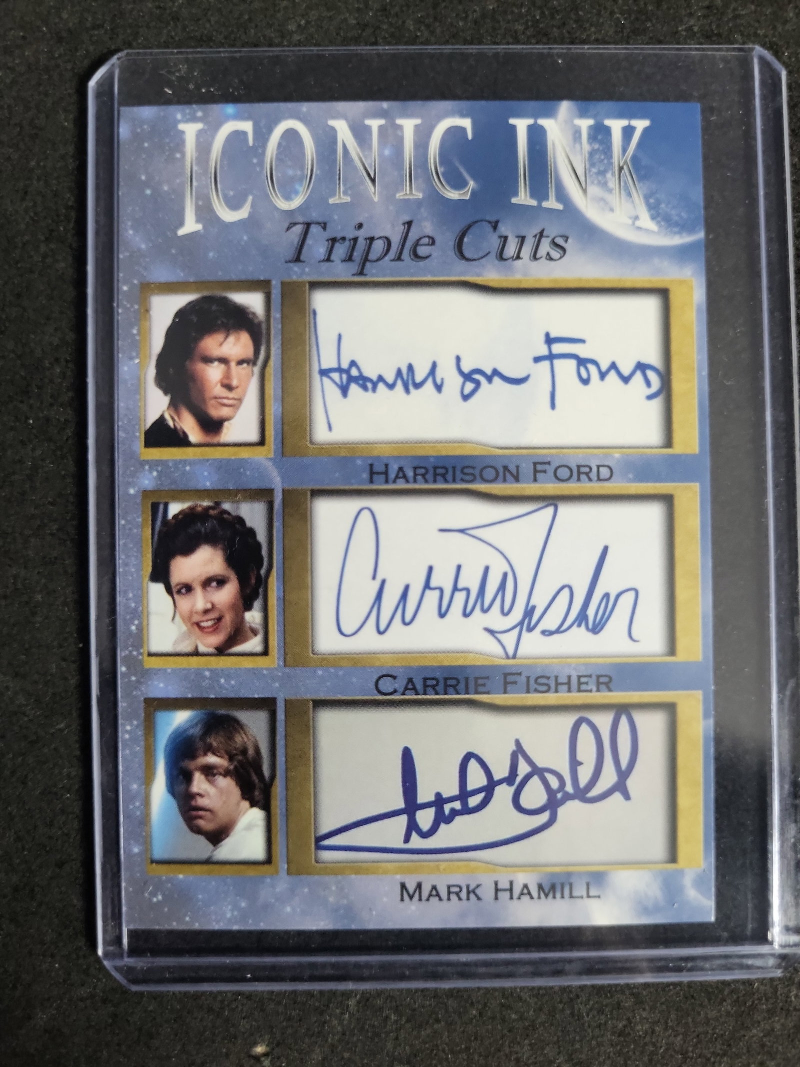 I03284 | Iconic Ink Triple Cuts Star Wars Facsimile Autograph Card Harrison Ford Carrie Fisher Mark: BID PER WHAT YOU SEE IN THE PHOTO, NOT THE AI GENERATED TITLES AND DESCRIPTIONS! An Iconic Ink Triple Cuts trading card featuring printed facsimile autographs of Star Wars cast members Harrison Ford, 