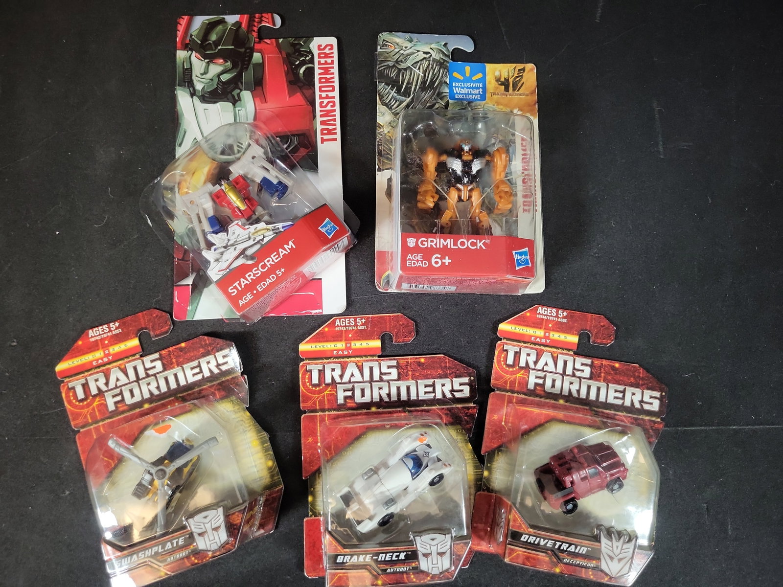I03511 | Five Hasbro Transformers Action Figures in Original Factory Packaging: BID PER WHAT YOU SEE IN THE PHOTO, NOT THE AI GENERATED TITLES AND DESCRIPTIONS! Five Hasbro Transformers Action Figures in Original Factory Packaging A collection of five Hasbro Transformers action f