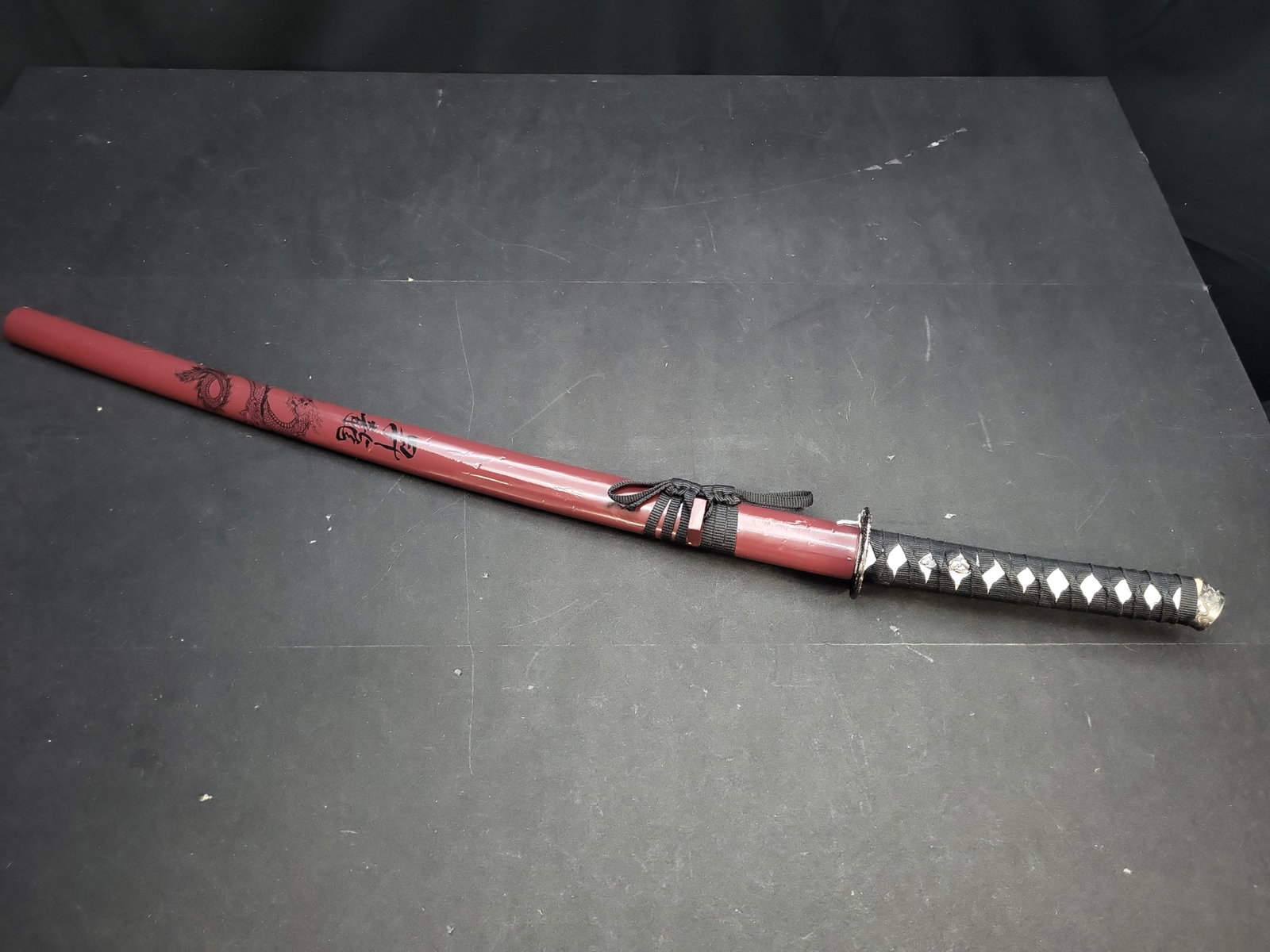 I04734 | Modern Katana with Maroon Scabbard: IMPORTANT â€“ PLEASE REVIEW BEFORE BIDDING: Aeron House makes every effort to accurately identify and describe each lot; however, titles and descriptions may contain errors, omissions, or AI-a