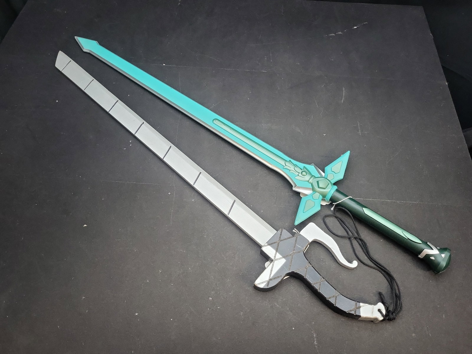 I04731 | A Pair of Anime Prop Swords: IMPORTANT â€“ PLEASE REVIEW BEFORE BIDDING: Aeron House makes every effort to accurately identify and describe each lot; however, titles and descriptions may contain errors, omissions, or AI-a
