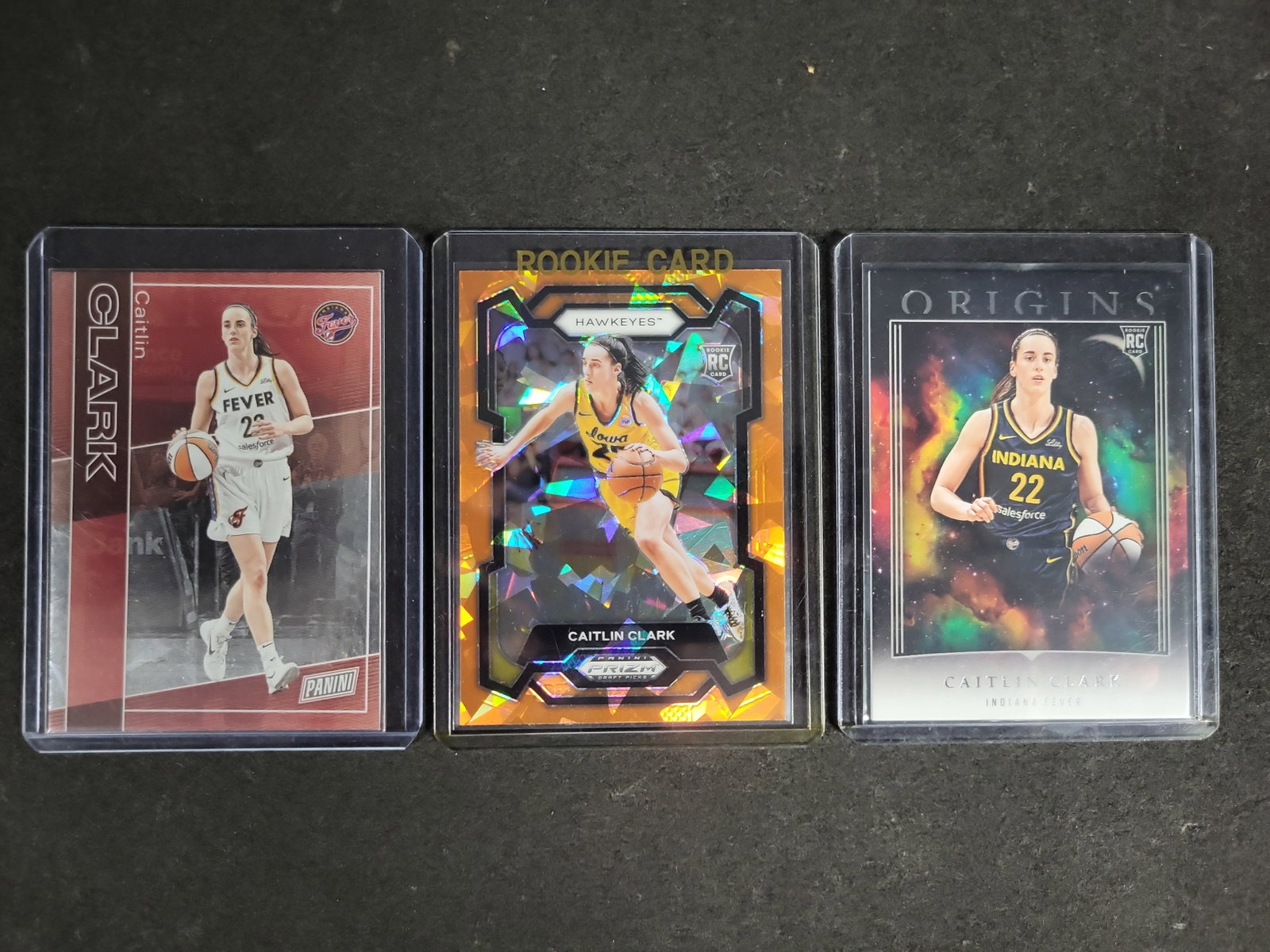 I04480 | Three Caitlin Clark Panini Trading Cards: IMPORTANT â€“ PLEASE REVIEW BEFORE BIDDING: Aeron House makes every effort to accurately identify and describe each lot; however, titles and descriptions may contain errors, omissions, or AI-a