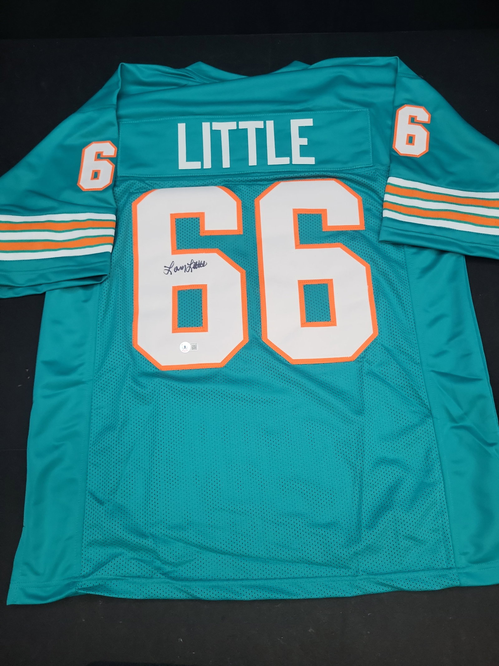 I04323 | Signed Larry Little Dolphins Jersey Beckett: IMPORTANT â€“ PLEASE REVIEW BEFORE BIDDING: Aeron House makes every effort to accurately identify and describe each lot; however, titles and descriptions may contain errors, omissions, or AI-a