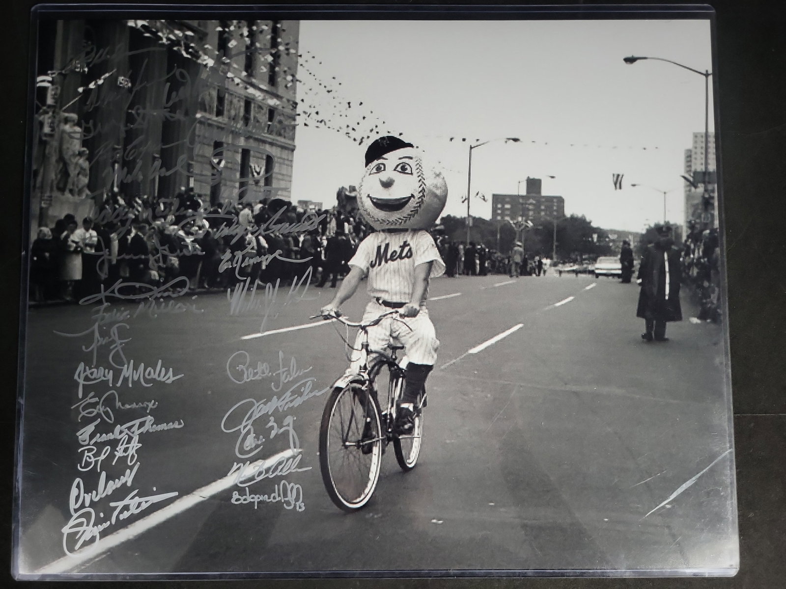 I04377 | Multi-Signed Mr. Met Parade Photograph: IMPORTANT â€“ PLEASE REVIEW BEFORE BIDDING: Aeron House makes every effort to accurately identify and describe each lot; however, titles and descriptions may contain errors, omissions, or AI-a