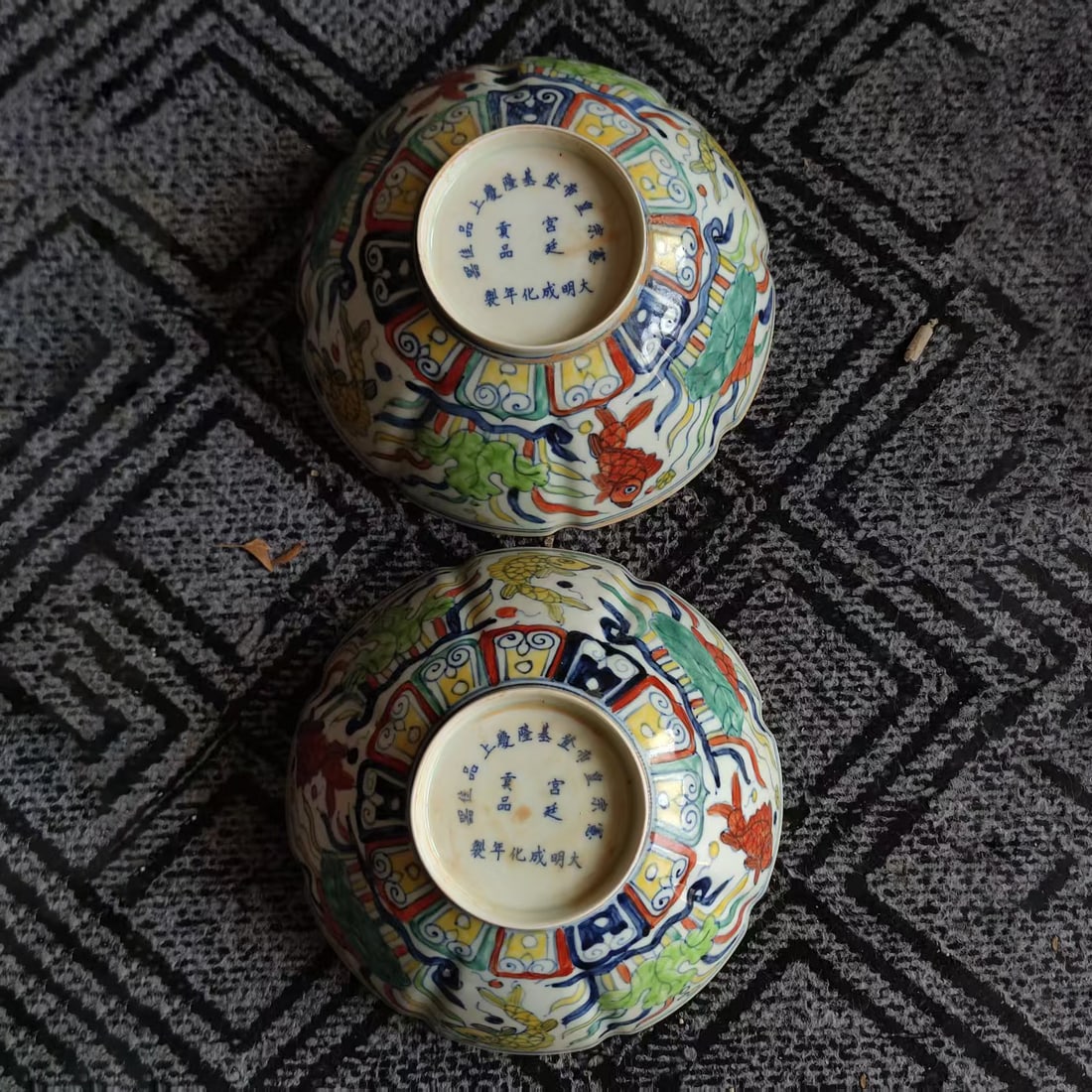A pair of Chenghua-style multicolored fish pattern bowls: A pair of Chenghua-patterned, five-colored fish design bowls from the Ming Dynasty, each with a diameter of 21 centimeters. The bowls feature a floral mouth shape and are adorned with fish algae decor