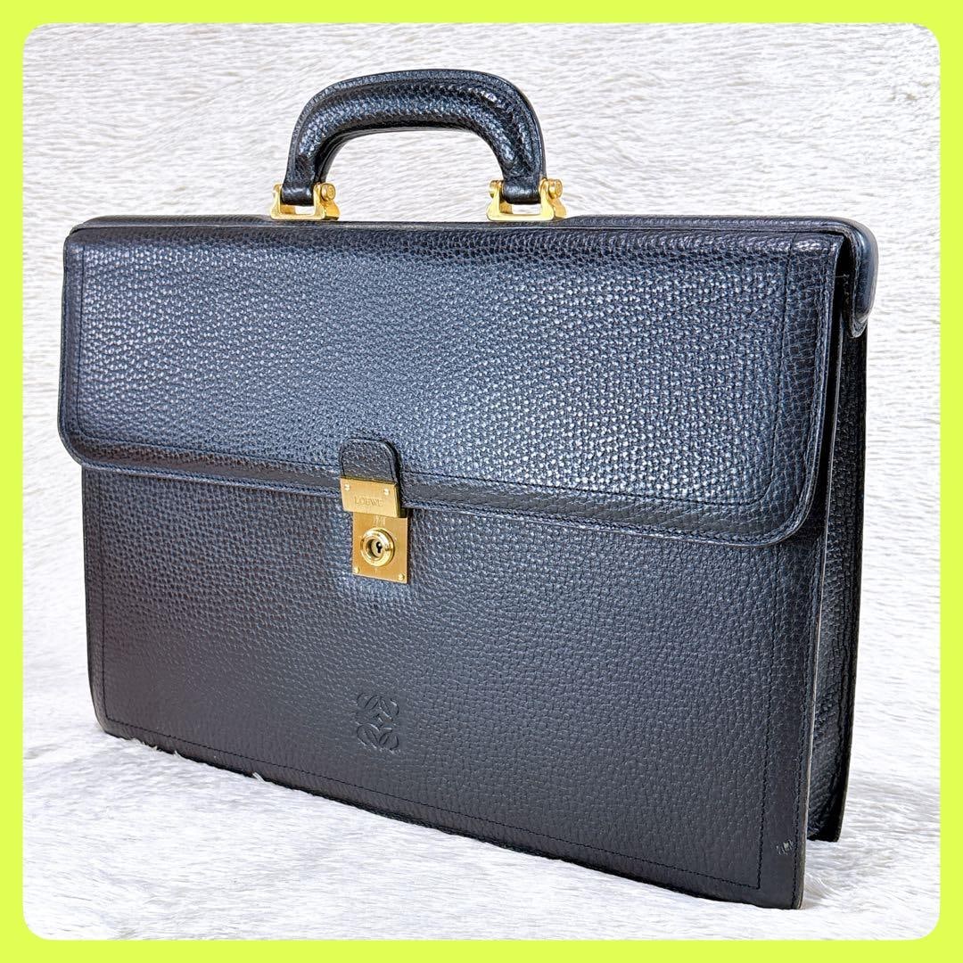 LOEWE Anagram Briefcase: LOEWE Anagram Briefcase, A4 SizeThis Loewe business bag/briefcase is made of black leather, featuring a rearranged letter pattern embossing and gold hardware accessories.The central gold hardware acce
