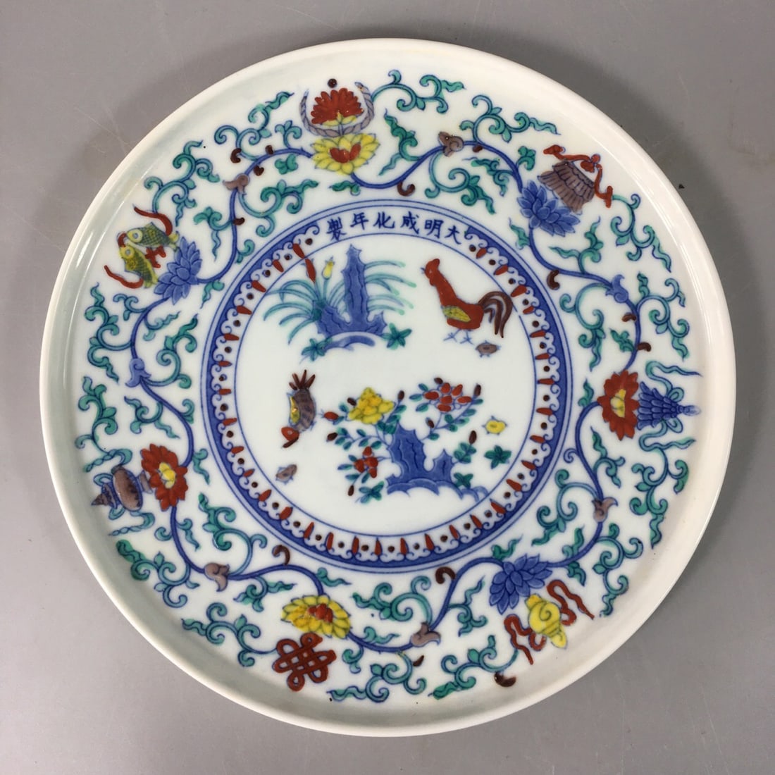 Ming dynasty style Chenghua famille-verte plate: Ming-style Chenghua Doucai plate, with delicate body and lustrous glaze. The center of the plate features traditional auspicious motifs such as a rooster, peonies, and reeds, executed with multiple la