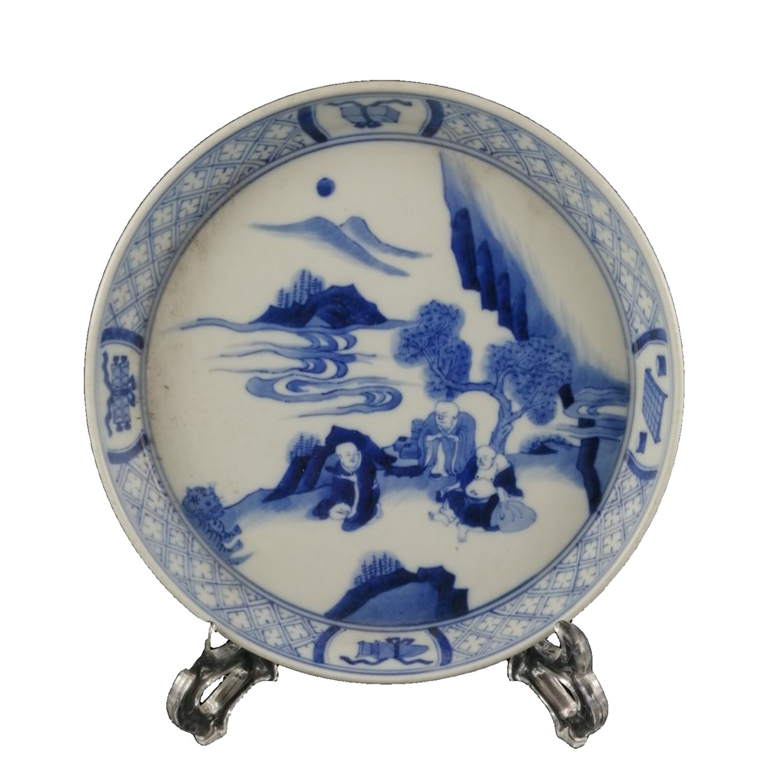 Kangxi Blue and White Arhat Landscape Decorative Plate: This plate, made during the Kangxi period of the Great Qing dynasty, features a blue and white design of Arhats amidst a mountainous landscape. The plate is well-proportioned with a moderate size, mea
