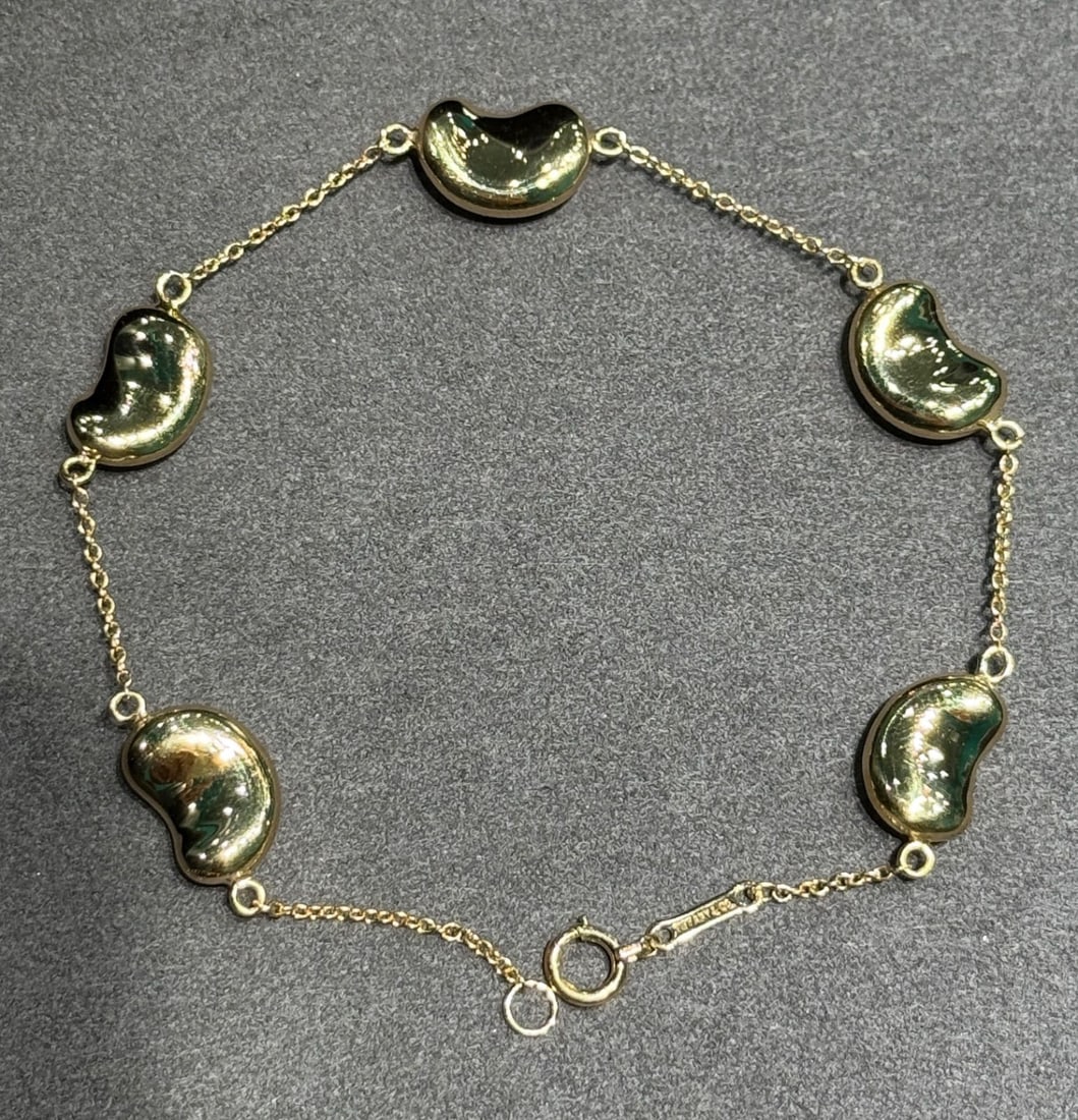 Second-hand Tiffany 18K Gold Bean Bracelet: Tiffany & Co. 18K Gold Bean Bracelet, 18K Gold, polished to perfection??Gross Weight?7.6 grams Freight: 1.International Freight: Foreign shipping charges are determined by destination. 2.Photos,