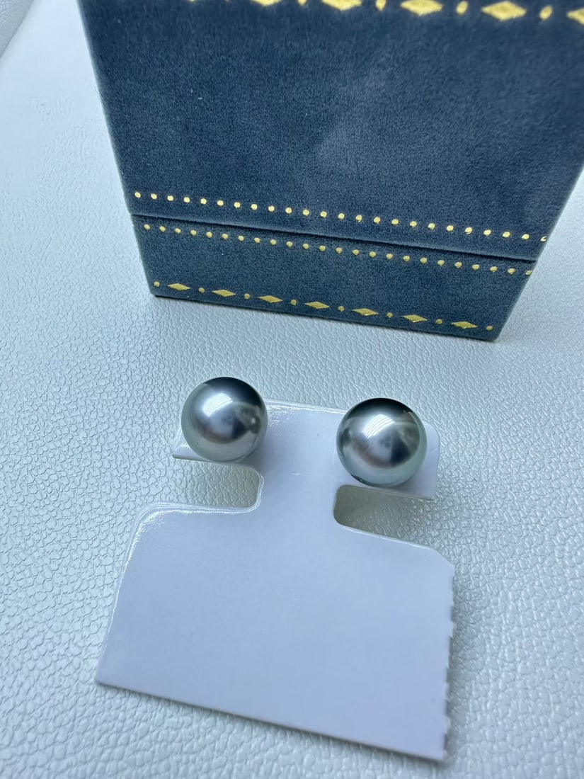 18K Gold Pearl Earrings: This is a pair of 18K gold earrings with needles, featuring 10-11mm platinum gray series plain studs, round and highly reflective, with flawless surface, and minor flaws at the bottom of the side, but