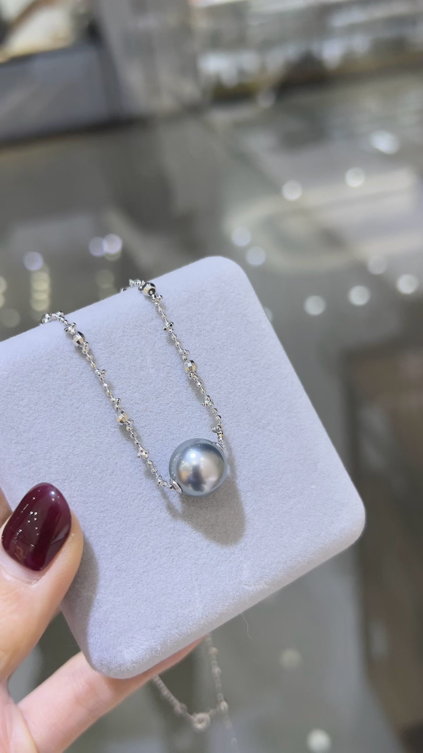 Platinum Gray Tahitian Pearl Necklace: This necklace is made from 11-12mm perfectly round Tahitian pearls with a genuine platinum gray color, paired with a silver chain, featuring an aurora effect on the pearl surface with slight blemishes
