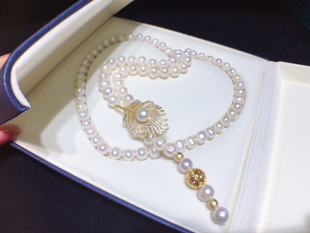 Feather Pearl Sweater Necklace: This is a powerful pearl sweater chain made of natural freshwater pearls, slightly flawed under strong light, with a diameter of about 8-9mm. The feather clasp design allows for easy adjustment, showc