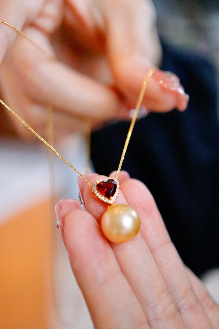 Gold Pearl Pendant: Natural Nanyang sea golden pearl, deep golden color, 18k heart-shaped garnet pendant, good quality leather, very slightly flawed, pearl diameter 11 to 12 millimeters, perfect round. Freight: