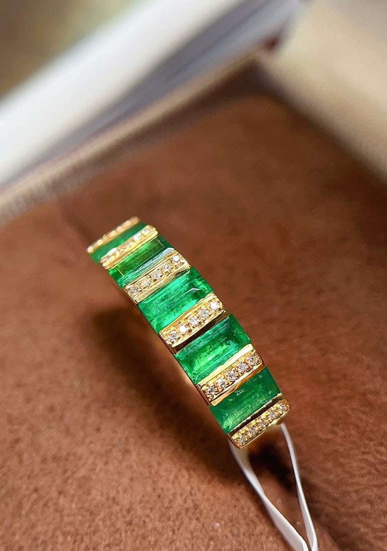 18k Gold Emerald Ring: This 18k gold emerald ring features a unique design, with a main stone of about 1.3 carats and adorned with 20 diamonds, with a total weight of 1.75 grams. The spicy green wood zhuo color is very eye-