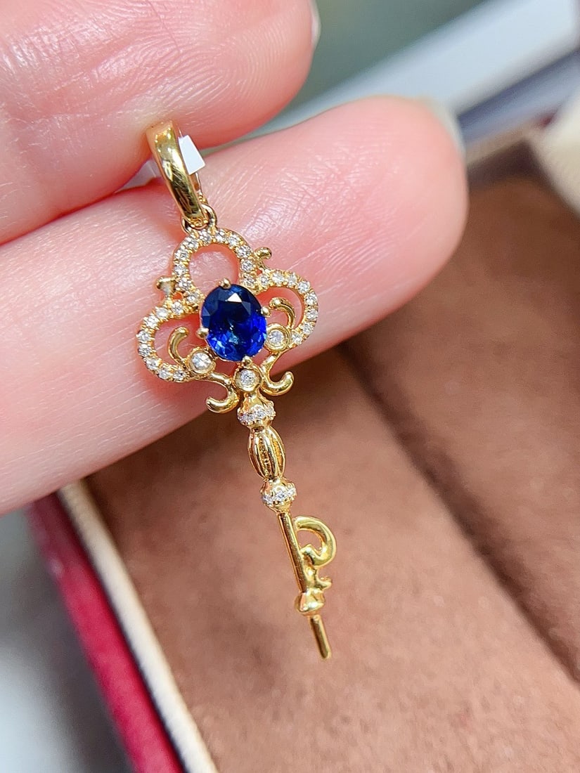18k Gold Sapphire Pendant: This pendant is meticulously crafted in 18k gold, with a rich cornflower blue sapphire emitting a charming luster, perfectly interpreting the essence of elegance. The key design symbolizes unlocking a