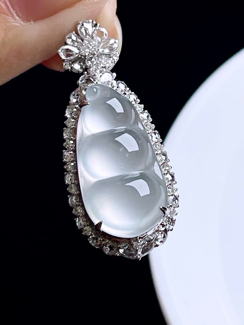 18k gold pendant inlaid with jadeite lucky bean: This 18k gold inlaid jade Fu bean pendant is an elegant and exquisite masterpiece. The jade, with its high ice-like luster, transparent clarity, and charming radiance, makes it a luxurious and elegant