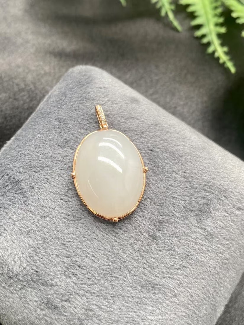 18k Gold Diamond and mutton fat Jadeite pendant: This pendant exudes an elegant and delicate charm, featuring luxurious 18k gold setting that perfectly complements the pure beauty of the creamy white jade. Diamond accents add a touch of sparkle, mak