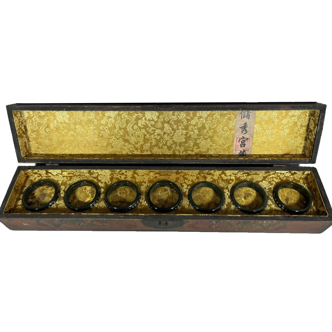 Qing Qianlong Nanmu Lacquer Box Jade Bracelet: This Qing Dynasty-era jade bracelet, accompanied by a well-preserved nanmu lacquer box, showcases a high level of craftsmanship. The bracelet has a translucent color, exquisite gold-engraved