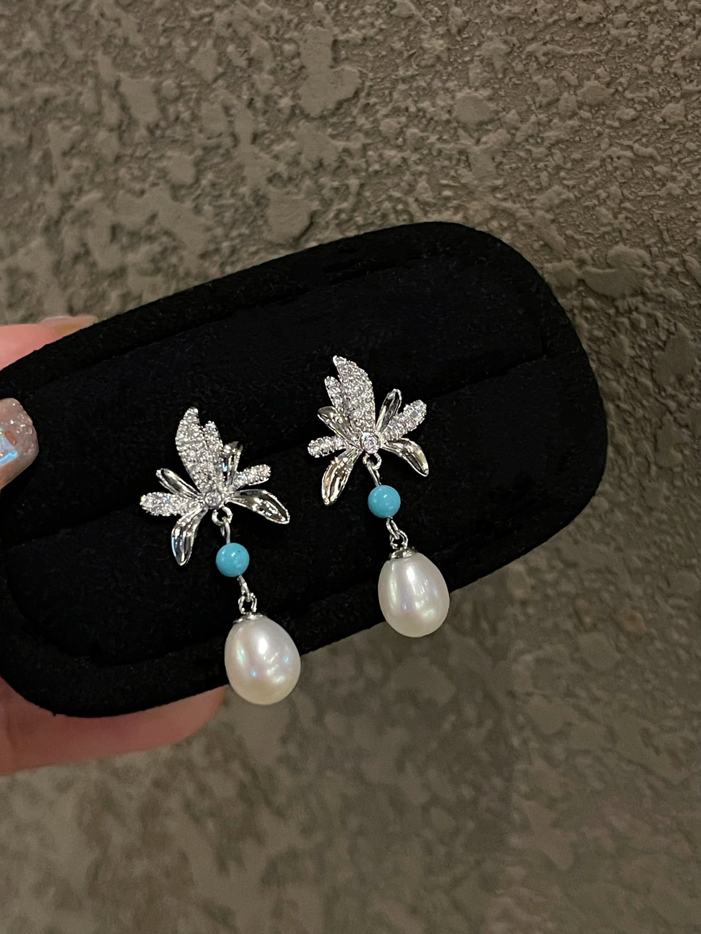 Silver Set Natural Freshwater Pearl Earrings: These earrings feature a harmonious blend of natural pearls and turquoise blue, capturing the lively essence of spring. The cool white luster of the pearls complements the silver leaf with diamond set