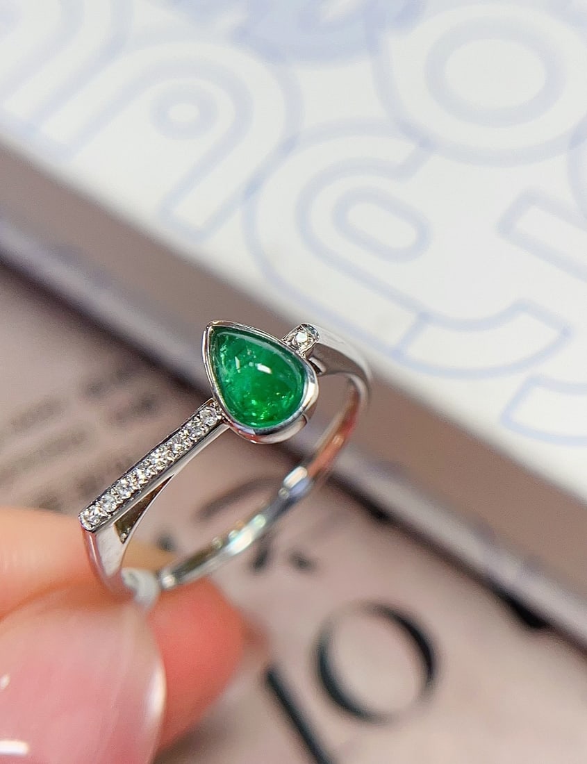 18K Gold Emerald Ring: This ring features 18K gold set with a natural emerald, showcasing a vivid green fluorescence. The minimalist design includes an emerald main stone of approximately 0.55 carats, complemented by 9 diam