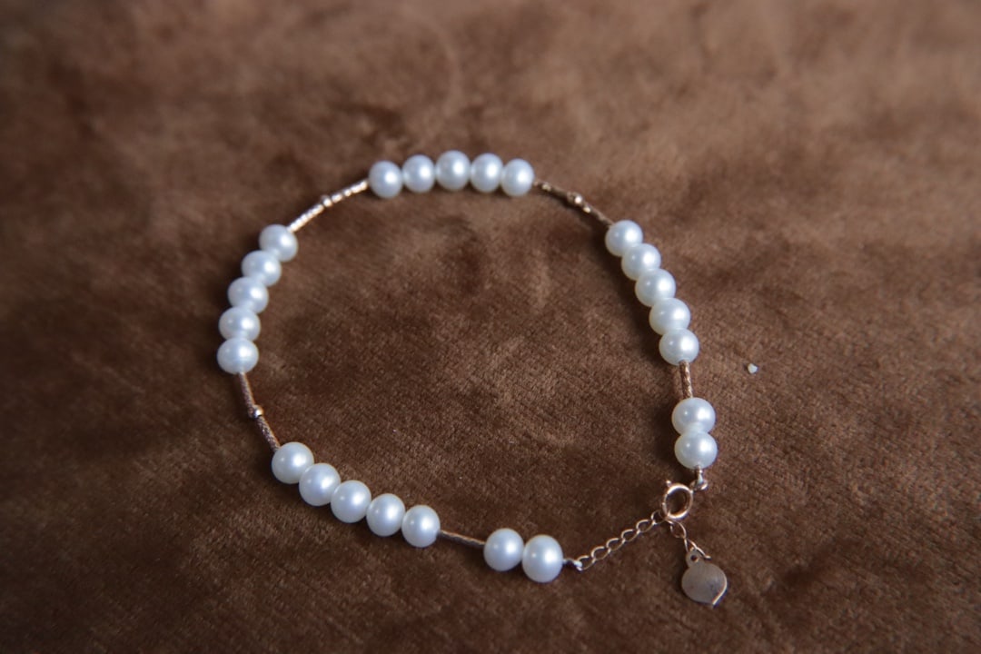 18K Gold Natural Freshwater Pearl Bracelet: This bracelet features 18K gold set with natural freshwater pearls, approximately 5mm in diameter, showcasing a near-round shape and intense luster. The pearls exhibit an elegant color and exceptional