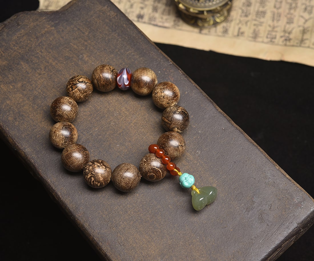 Natural Agarwood Bracelet: This natural agarwood bracelet is crafted from wild aged material, showcasing a rich black resinous luster with full beads. The fragrance is intensely sweet with floral notes and a penetrating coolnes
