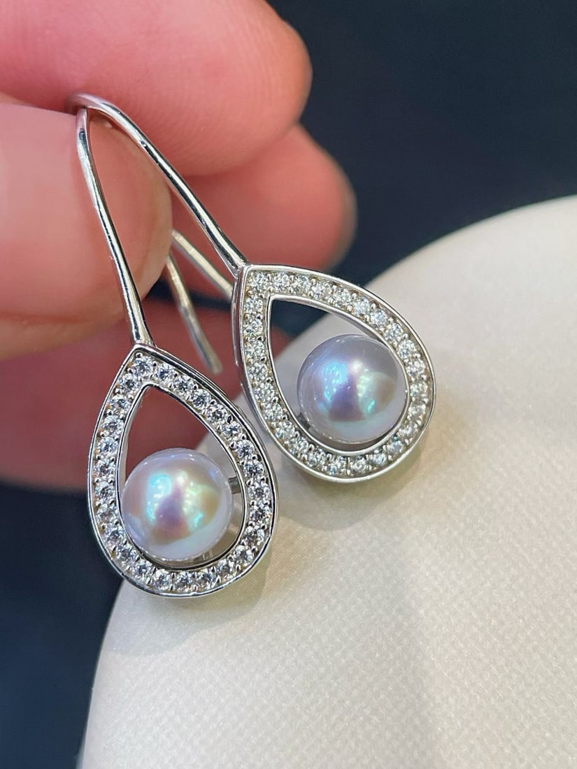 S925 Silver Natural Drop Earrings: These earrings feature natural drop stones with a pristine luster, showcasing an elegant gray iridescence. The perfectly round design and near-flawless surface emit a subtle pink-purple hue under cool