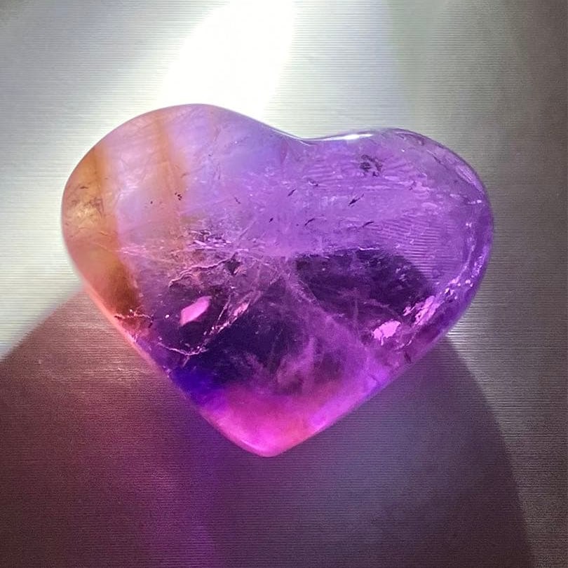 Bicolor Amethyst Natural Heart-Shaped Palm Stone: **Bicolor Amethyst Natural Heart-Shaped Handheld Stone, Infused with Spiritual Power** **[Product Description]** This is a heart-shaped carving made from amethyst. The most captivating feature of