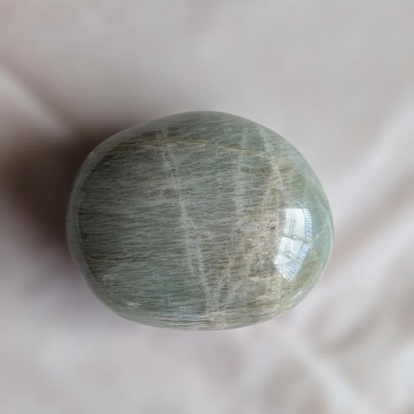 Magnesium-Aluminum Stone Hand Stone: Magnesium Aluminum Stone Hand Stone This is a nickel magnesium alum hand stone. There are no noticeable scratches or chips, but it features patterns and inclusions characteristic of natural stone.