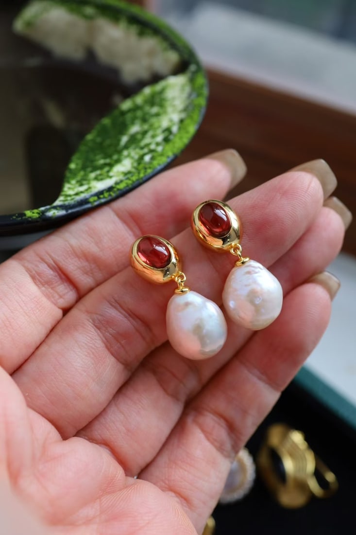 Natural Pearl Earrings: These earrings feature natural pearls as the main stone, showcasing an elegant luster. Paired with natural garnet, they add a touch of enchanting color. The overall design is simple yet sophisticated.