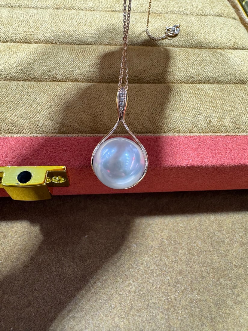 18K Gold Diamond Australian White Pendant: This pendant is meticulously crafted in 18K gold, featuring diamonds and Australian white pearls, showcasing a perfect blend of elegance and luxury. The pearl diameter is 12-13mm, nearly round with st