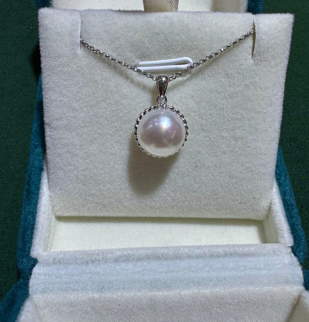 18K Diamond and Pearl Pendant: This pendant features a simple twist design, paired with an 11mm Australian white pearl, showcasing near-round strong luster and flawless smoothness. The exquisite craftsmanship and high-quality mater
