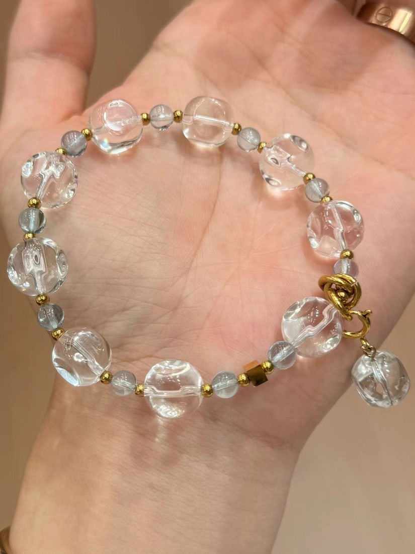 18K Gold White Crystal Bracelet: This bracelet features white crystal as the main stone, complemented by topaz spacer beads, showcasing a simple yet elegant style. The high-color-retention 18K gold fittings add a touch of luxury to t