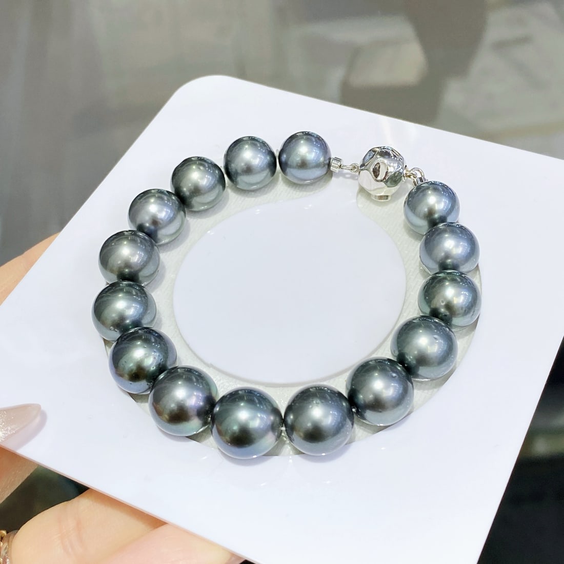 Sterling Silver Tahitian Pearl Bracelet: This bracelet features Tahitian pearls with peacock green strong luster. The pearls are smooth and shiny, complemented by a sterling silver design, exuding a high-end, gender-neutral appeal. (Pearl