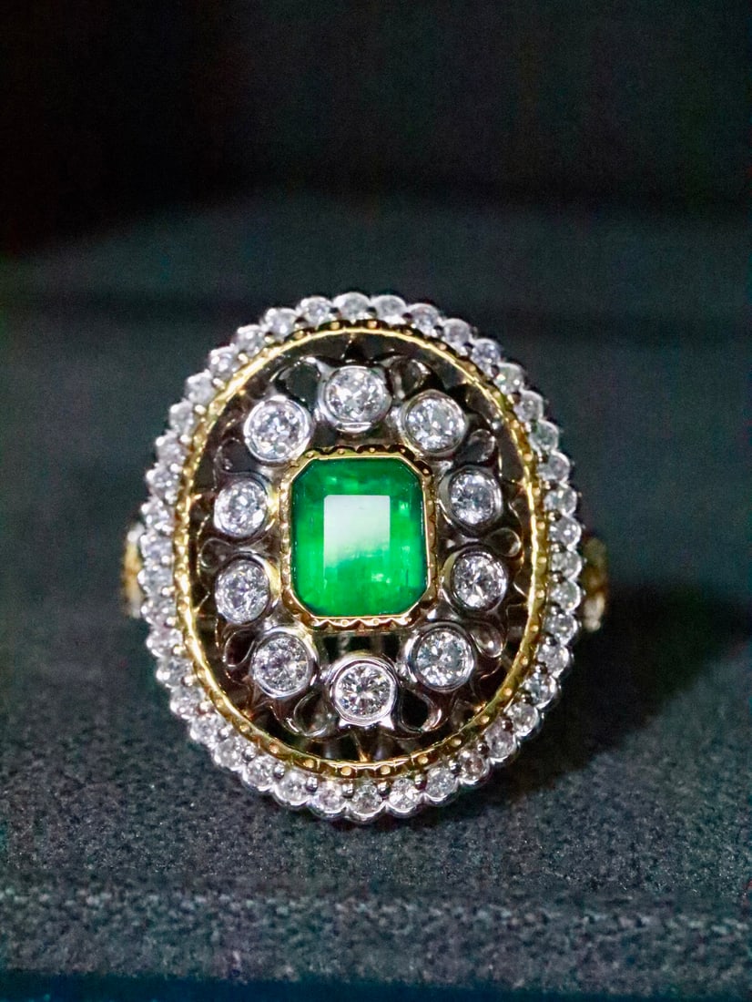 Natural Emerald Ring: This ring features a flawless emerald gemstone with exceptional fire and clarity. The delicate two-tone band design exudes luxury. (Gold weight 7.654g, center stone 0.73 carats, diamond 0.252 carats, 