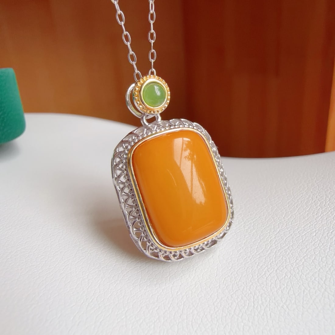 Natural Amber Pendant: This pendant features a natural amber as the main stone, showcasing a unique sugar cube shape, set in S925 sterling silver, blending classic and modern styles. The dual-tone plating adds a