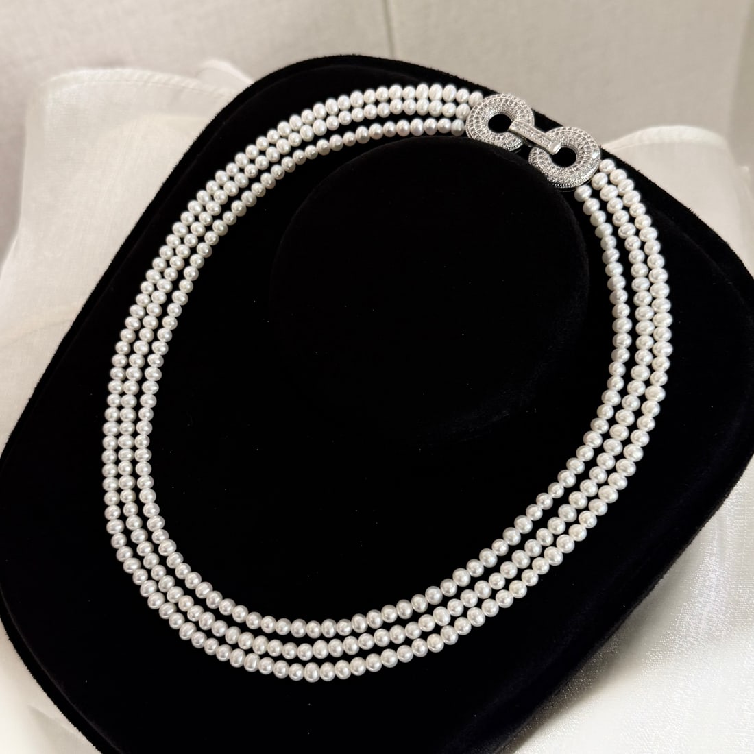 Natural Freshwater Pearl Necklace: This necklace is crafted from high-quality natural freshwater pearls, nearly round with strong luster and slight blemishes. The three-layer design allows for flexible wearing styles, showcasing an