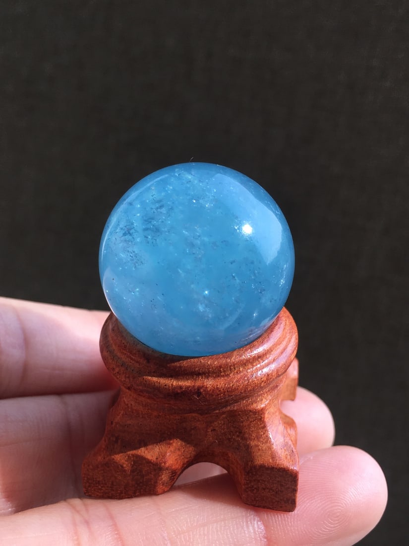 Natural Aquamarine Crystal Ball Ornament: This aquamarine crystal ball showcases the pure beauty of Santa Maria blue. The crystal is transparent with even color, captivating the beholder. Suitable for collection or as an elegant decoration. (