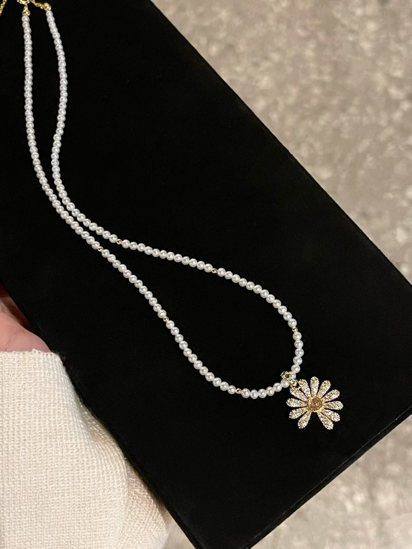 Natural Freshwater Pearl Pendant: This pendant features a fully diamond-studded three-dimensional daisy design, showcasing exquisite craftsmanship and unique design. The soft luster of the natural freshwater pearl adds a touch of