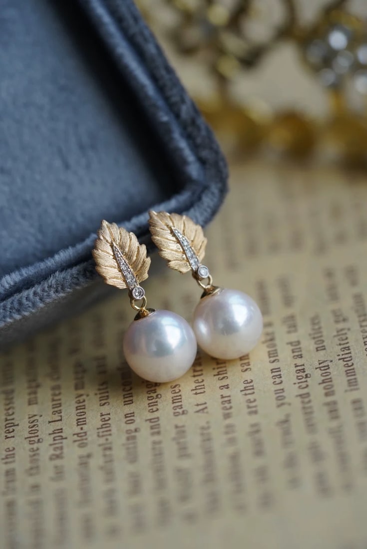18K Gold Perfectly Round Flawless Pearl Earrings: These earrings are crafted in 18K gold, showcasing a unique leaf design. The perfectly round flawless pearls exude a noble luster. Accented with 0.03 carat diamonds, they add a touch of luxury. (Pearl