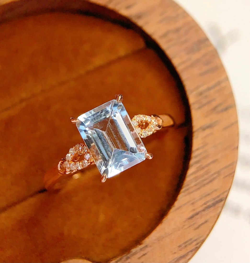 18K Gold Natural Aquamarine Ring: This ring is meticulously crafted in 18K gold, featuring a brilliant natural aquamarine that exudes a captivating glow. It is adorned with 18 diamonds, adding a touch of luxury. The overall design is 