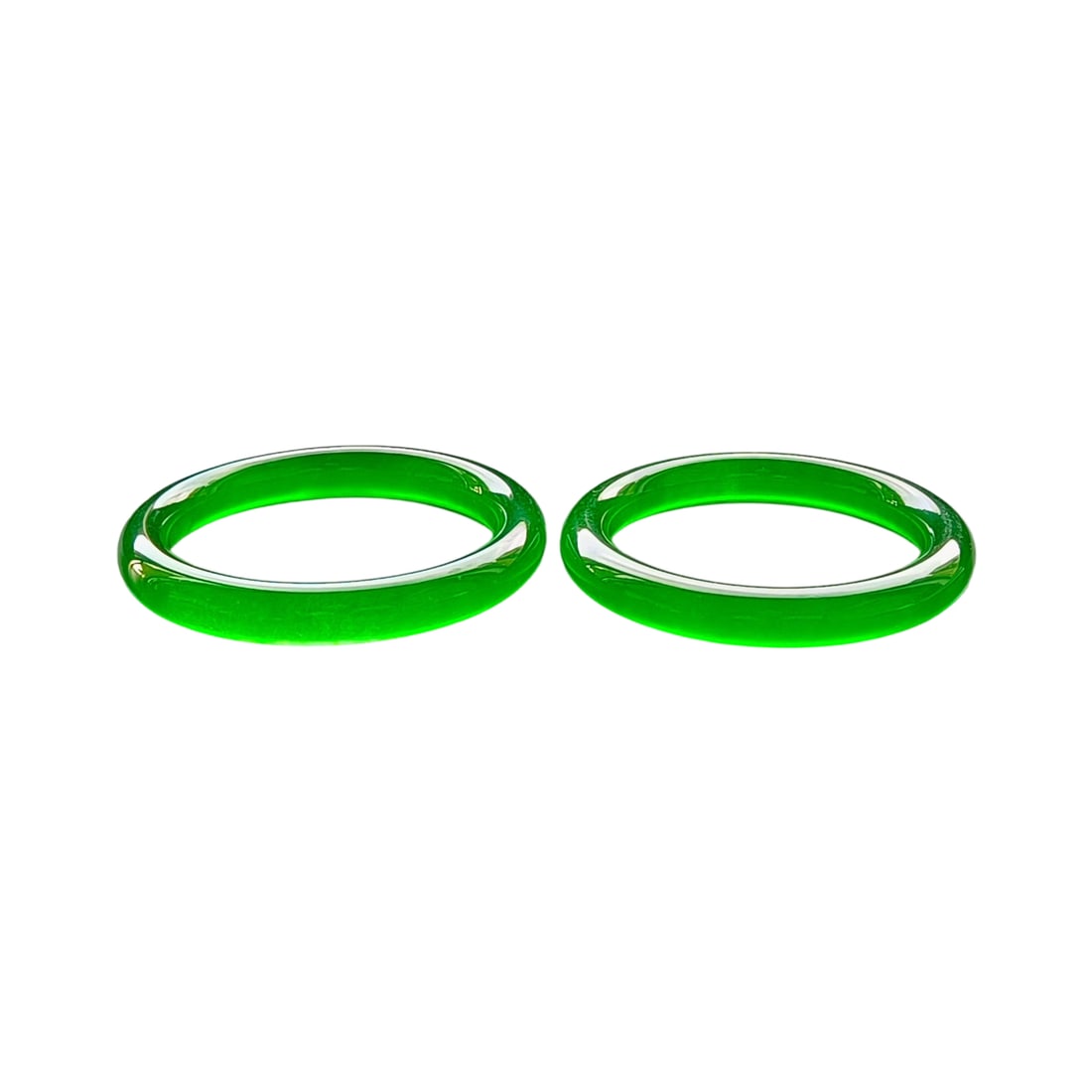 Top Dragon Stone Imperial Green Jadeite Bracelets: This pair of jadeite bracelets is renowned for its Dragon Stone Imperial Green hue, showcasing excellent translucency. The perfect texture and color are evident even under UV light. The craftsmanship 