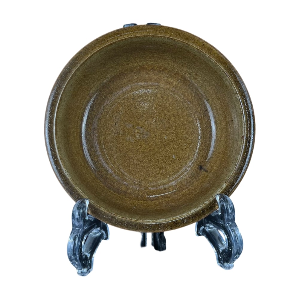 Song Dynasty Longquan Kiln Yellow Glaze Dish: This Song Dynasty Longquan kiln yellow glaze dish showcases an elegant color and exquisite craftsmanship. The yellow glaze is as warm as jade, presenting a unique ancient beauty. The dish has a regula