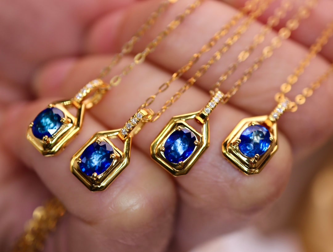 18K Gold Sapphire Pendant: This pendant is meticulously crafted in 18K gold, featuring a captivating sapphire complemented by four sparkling diamonds, showcasing an elegant design. The overall design is simple yet luxurious,