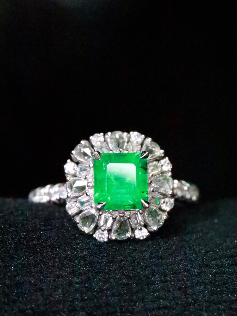 PT950 Natural Emerald Ring: This platinum ring features a brilliantly clear emerald, showcasing a classic design aesthetic. The emerald's vivid color is complemented by sparkling diamonds, creating an elegant and sophisticated