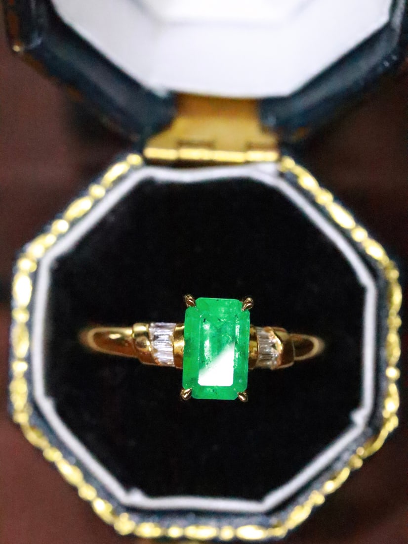 18K Gold Emerald Ring: This 18K gold emerald ring perfectly combines elegance and sophistication. The captivating color of the emerald adds a touch of luxury to the wearer. The diamond accents enhance its opulence. (Main