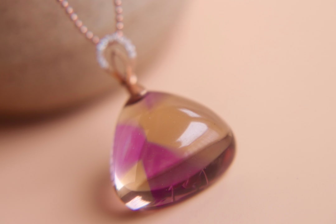 18K Gold Bi-color Ametrine Diamond Pendant: This pendant is meticulously set in 18K gold, showcasing the enchanting color transition of bi-color ametrine with a pure and flawless crystal. Paired with diamonds, it adds a touch of luxurious